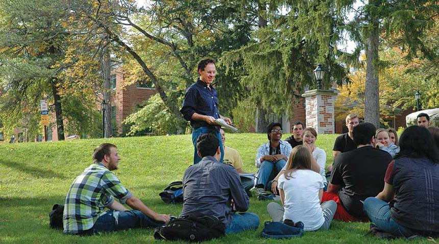 students in class with professor outdoors